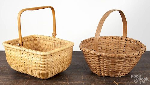 Two splint gathering baskets, 20th c., one with a swing handle and wood floor, 5 1/2'' h., 11'' w.