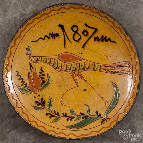 Greg Shooner redware charger with sgraffito peacock decoration, dated 2000, 12 1/2'' dia.