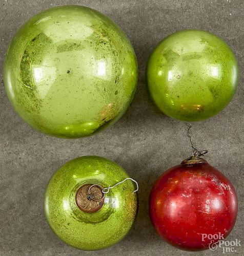 Three green round kugels, 2 3/4'' dia., together with a red example, approx. 3 3/4'' dia.