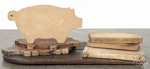 Seven wooden cutting boards, 19th/20th c., to include three pigs and one large pine tombstone, 29'' h