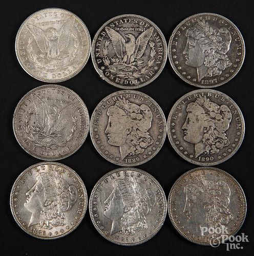 Nine Morgan silver dollars, 1881-1904.