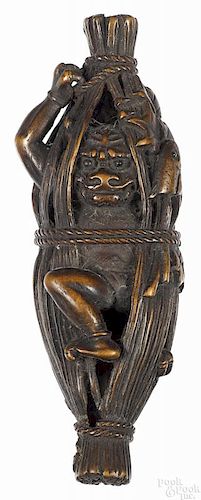 Japanese carved wood ogre in a fish trap netsuke,
