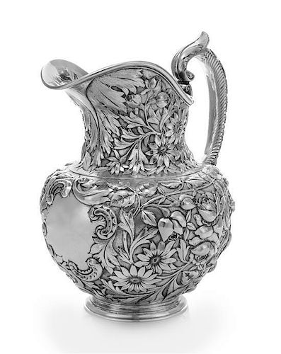 * An American Silver Water Pitcher, J.E. Caldwell, Philadelphia, PA, the baluster form body having repousse floral and foliat