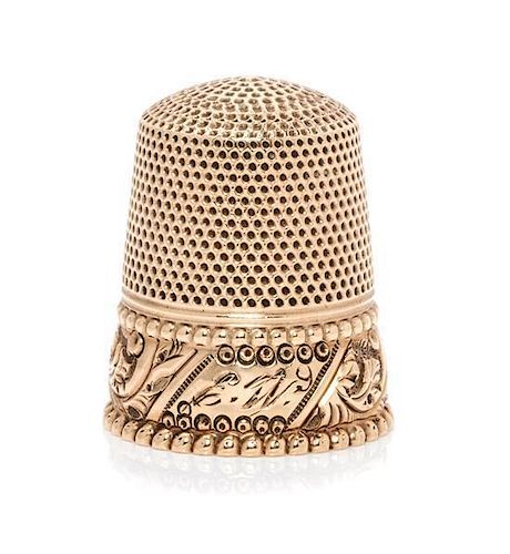 * An American Yellow Gold Thimble, , having a knurled top and body above a foliate band with an engraved cartouche within two