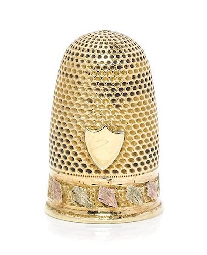 * A Continental Tri-Color Gold Thimble, , the knurled domed top and body above a rose and white gold band of continuous folia