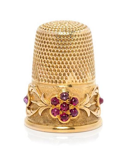 * A Continental Yellow Gold and Ruby Thimble, , the knurled top and body surmounting a floral and foliate decorated band, the