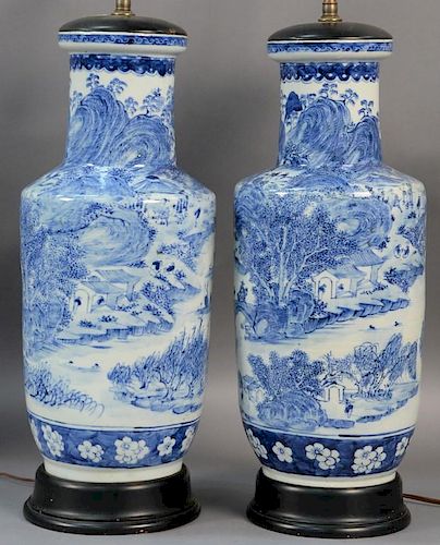Pair of Chinese blue and white porcelain vases having painted mountainous landscape scene made into table lamps.  ht. 18in.