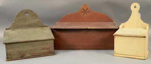 Three primitive wall boxes with lift tops including a white painted box with lollipop hanger, a large red painted box with ca