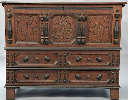 Sunflower chest having lift top over sunflower carved panels flanked by turned applied ornaments over two long drawers