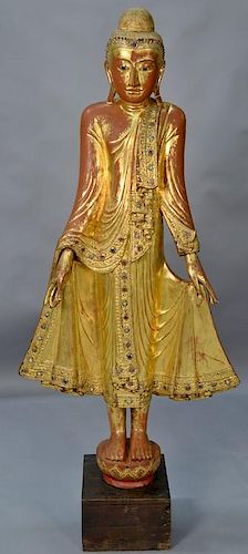 Life size Southeast Asian carved gilt and red lacquered figure of a Buddha dressed in stylized gilt and jeweled robe with elo