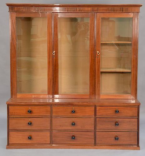 English mahogany and mahogany veneered cabinet in two parts, the upper section in the form of a bookcase with moulded cornice