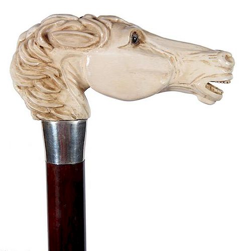 64. Mammoth Horse Dress Cane-20th Century- A large thick carving in mammoth ivory of a horse with two color glass eyes and fu