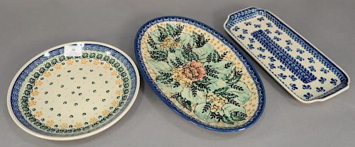 Twelve handmade Polish pottery pieces to include a set of nine dinner plates (dia. 10 1/2in.) and three oblong serving trays 