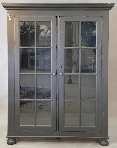 Contemporary two door cabinet with glass doors and wood shelves. ht. 69in., wd. 49in., dp. 14in.