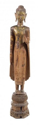 * A Thai Carved Wood Figure of a Standing Buddha Height 64 inches.