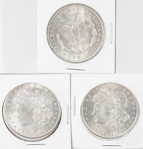 Three 1921 Morgan silver dollars.