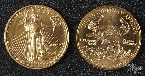 Two American eagle twenty-five dollar gold coins.