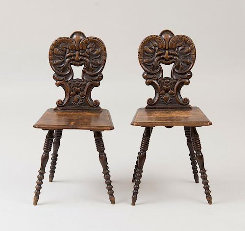 PAIR OF CONTINENTAL CARVED AND STAINED WALNUT HALL CHAIRS