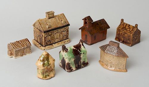 SEVEN GLAZED POTTERY BANKS IN THE FORM OF BUILDINGS