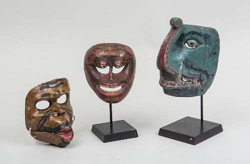 THREE SOUTHEAST ASIA PAINTED MASKS, TWO ON STANDS