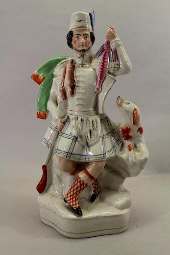 Staffordshire figure of kilted Scotsman with Dog