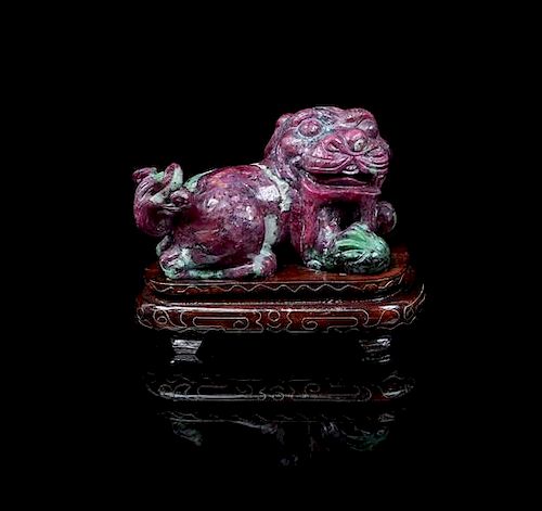 A Carved Ruby and Zoisite Fu Dog,, , carved of a single piece of ruby-in-zoisite rough and formed to emphasize the deep reddish
