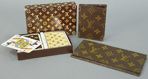 Three Louis Vuitton pieces including Louis Vuitton playing cards, Louis Vuitton wallet, and Louis Vuitton checkbook.