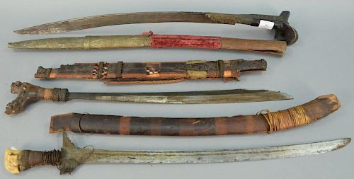 Group of three mid-eastern swords with sheaths including a long sword with incised writing and carved wood handle and two wit