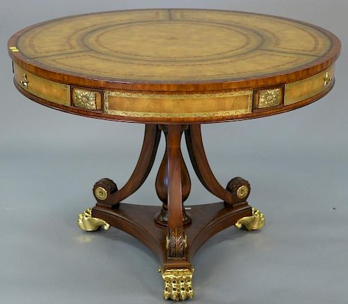 Maitland Smith mahogany drum table with leather top having sides and base with gilt metal feet. ht.28in., dia. 40in.