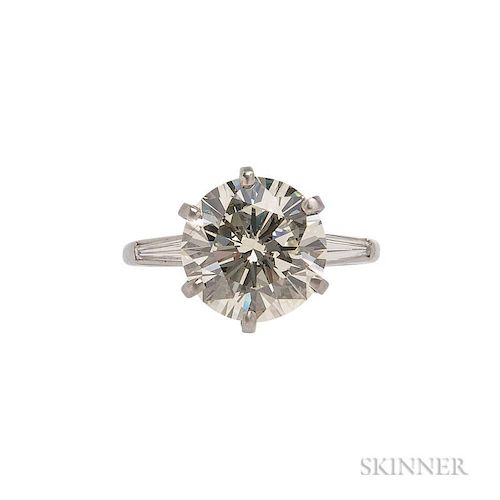 Platinum and Diamond Solitaire, the full-cut diamond weighing 5.31 cts., flanked by tapered baguettes, size 7 3/4.