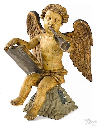 Carved and painted cherub with book and horn