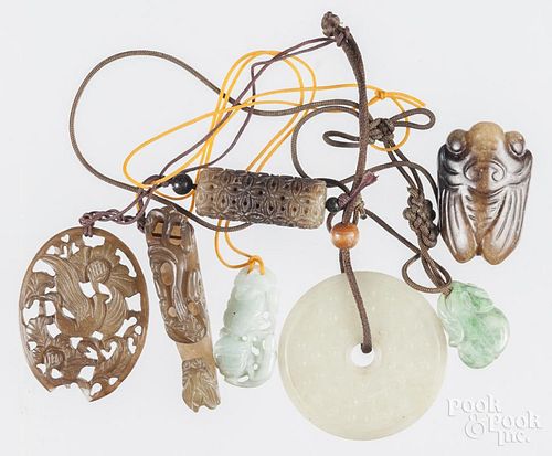 Seven Chinese carved jade and stone pendants.