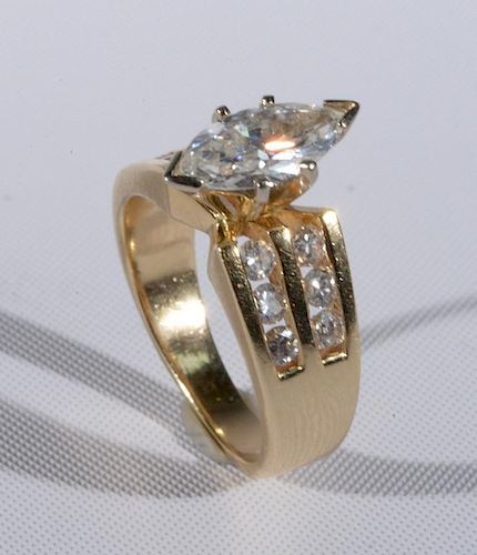 14 karat yellow gold engagement ring set with marquis diamond approximately 1.0ct flanked by six diamonds on either side. siz
