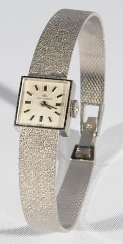 Movado 14 karat white gold ladies wristwatch with gold band being sold with original box. total weight approximately 20 grams
