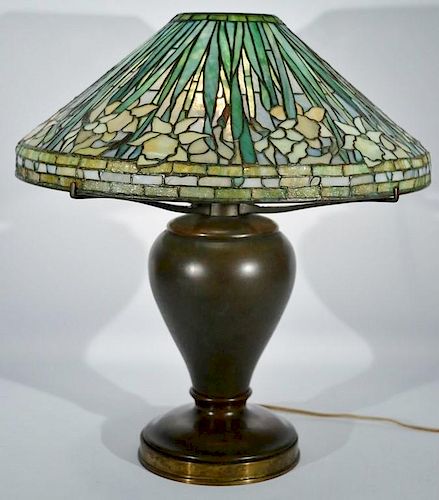 Tiffany Studios Daffodil table lamp having leaded Favrile glass shade with cascading daffodils on bronze oil converted to ele