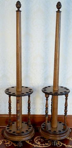 Pair of oak round revolving cue stick holders, each with center column with pineapple top, twelve cue holders each set on rou
