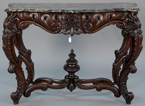 Victorian walnut hall table having cookie corner marble top on carved base with cabriole legs and center stretchers and finia