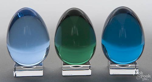 Three Baccarat colored glass eggs, signed on egg and stands, 2 3/4'' h.