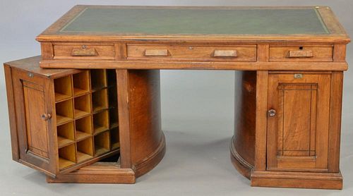 Wooton desk having leather top surrounded by burl walnut on double revolving pedestal base, ht. 31in., top. 32" x 59"