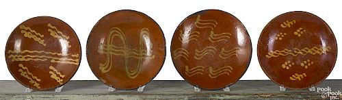 Four Pennsylvania redware chargers, 19th c.