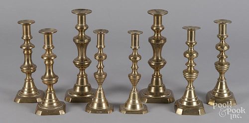 Four pairs of English brass candlesticks.