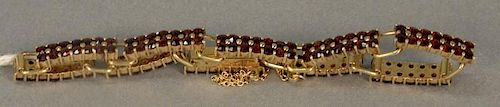 18K gold bracelet with ten rectangular sections, each set with 14 red stones, 15.7 grams.