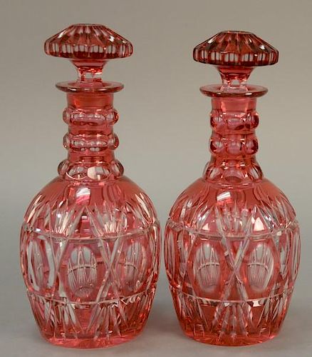 Pair of cranberry cut to clear decanters with stoppers. ht. 11 1/2in.