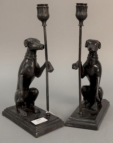 Pair of Maitland Smith bronze dog candle holders having seated dog with paw up holding candlestick, ht. 13in., wd. 7 1/2in.