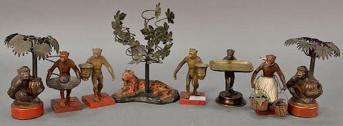 Group of eight figural candle holders including pair of painted metal and brass monkey candle holders, bronze monkey card hol