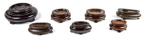 A Group of Seven Carved Wood Snuff Bottle Stands, Diameter of largest 2 1/2 inches.