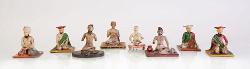 EIGHT INDIAN CARVED AND PAINTED WOOD FIGURES IN PRAYER