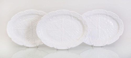 SET OF THREE PORTUGUESE WHITE GLAZED POTTERY PLATTERS MOLDED WITH CABBAGE LEAVES