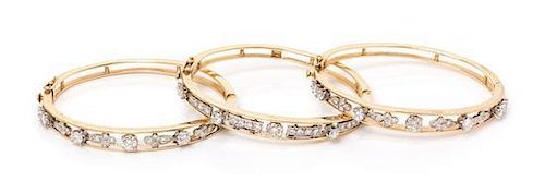 A Collection of 14 Karat Bicolor Gold and Diamond Bangle Bracelets, 31.50 dwts.