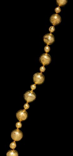 * An Akan Gold Alloy Bead Necklace, CÃ™te d'Ivoire/Ghana, strung with 31 round beads in alternating sizes.
